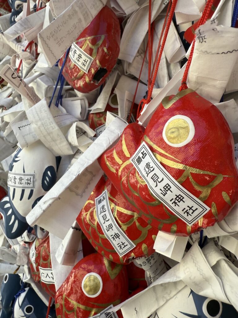 遠見岬神社の赤いキンメダイ絵馬のアップとおみくじ