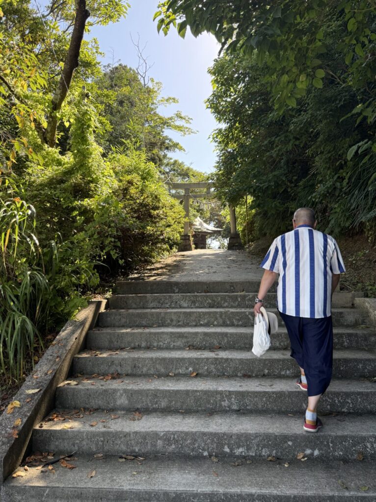 山道を進み、上の鳥居に向かう参拝中の男性